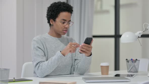 Young African Woman Using Smartphone at Work 