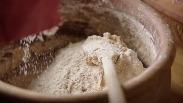 BAKING - Hand sprinkling flour on batter, sourdough bread baking, slow motion