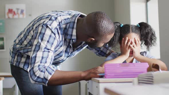 Video of african american male teacher supporting sad biracial girl