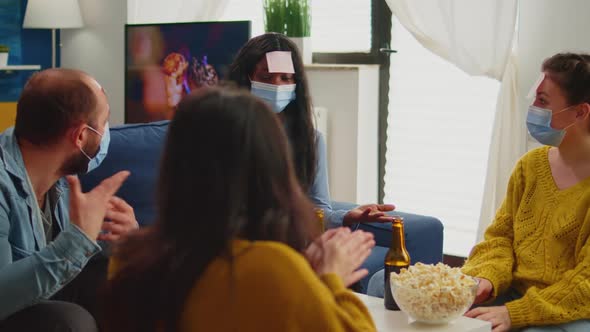 African Woman Playing Name Game with Sticky Notes on Forehead