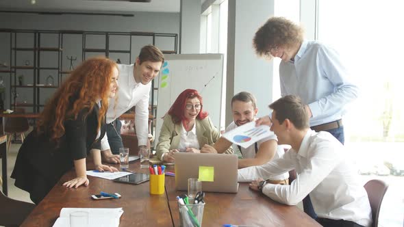 Cheerful Office Employees of a Business Company Sharing a Table