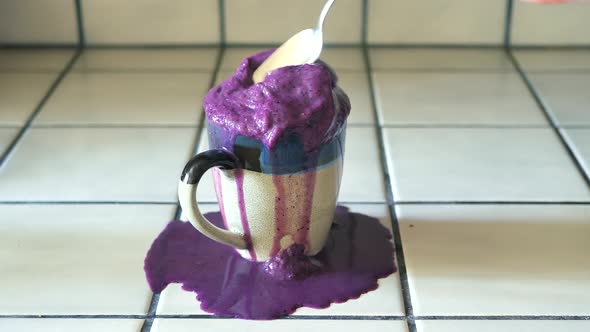 Making a huge colorful mess with a healthy, bright purple smoothie.