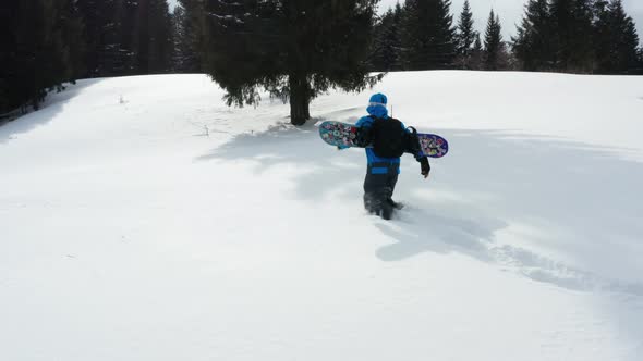 Aerial View of a Snowboard Going Uphill Near the Village at Sunset