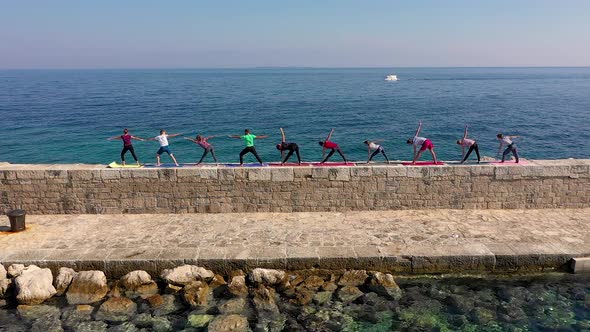Aerial view of group practicing yoga at artificial pier, Veli Losinj, Croatia.