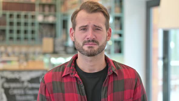 Portrait of Upset Young Man Crying at Camera 