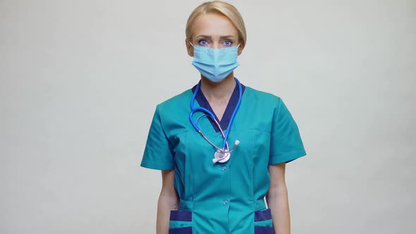 Medical Doctor Nurse Woman Wearing Protective Mask and Gloves - Showing Presenting Mobile Phone