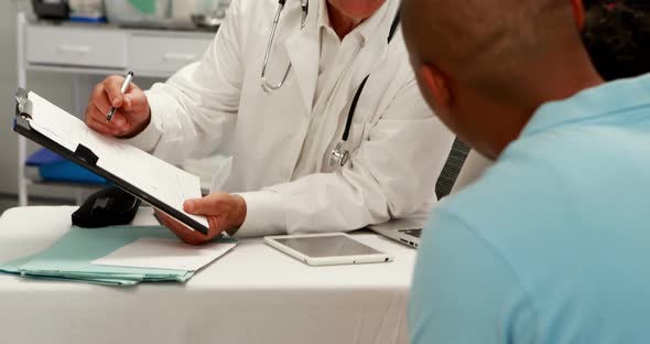 Male doctor discussing medical report with patient