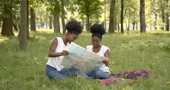 African Female Friends with a Map in Park