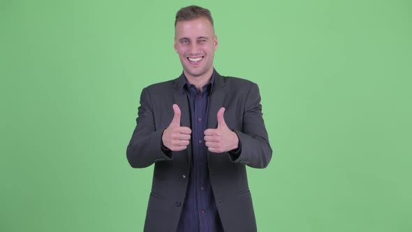 Happy Handsome Businessman in Suit Giving Thumbs Up and Looking Excited
