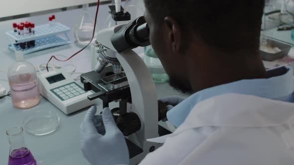 African-American Male Scientist Using Microscope