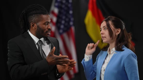 African American and Caucasian Diplomats Arguing at Press Conference with USA and German Flags at