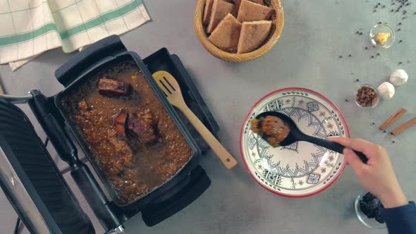 A top view of a chef cooking beef with honey and tajin. The chef is placing the beef meat on a plate