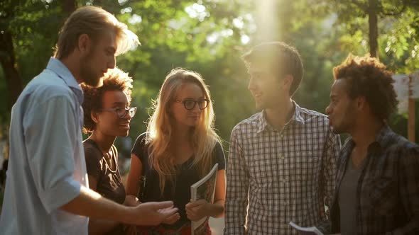 Caucasian and African American Female and Male Friends Talking Smiling in Park Showing Ok with