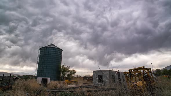 Timelapse of odd clouds moving over old farm equipment during storm