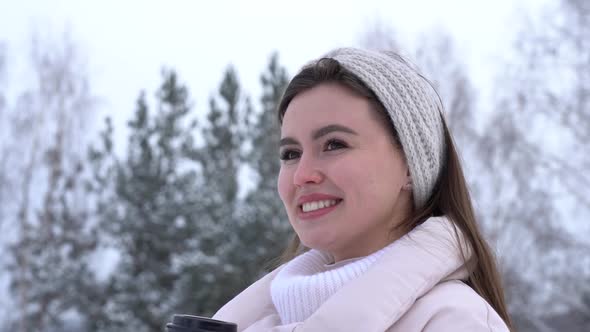 Young Attractive Girl Smiling in the Winter in the Forest