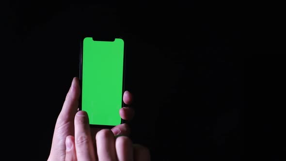 Smartphone with chromakey screen on black background. Place for dvertising on a smartphone