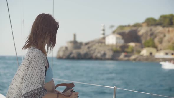 Beautiful Woman on a Yacht Enjoys the Journey on the Background of the Islands of Ibiza or Mallorca