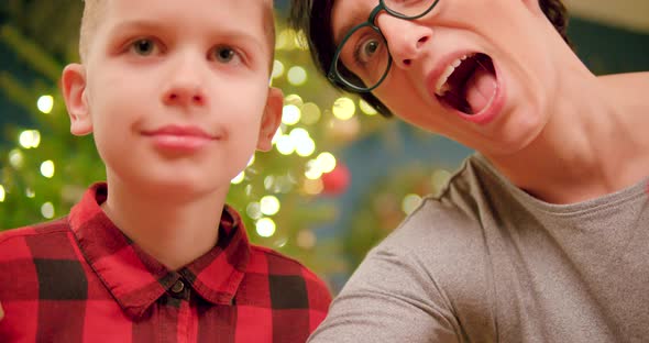 Mother and son open a Christmas present and looking happily into the opened gift