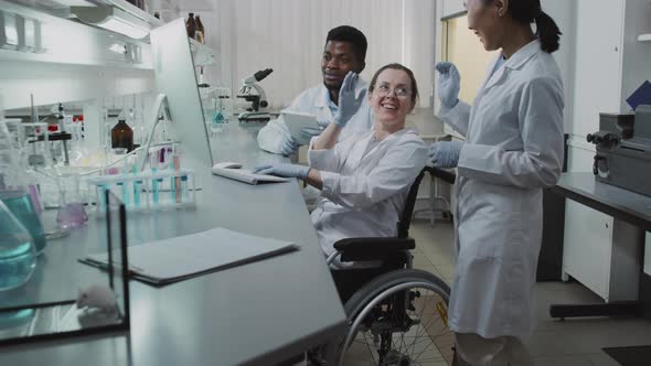 Happy Scientists High-Fiving in Lab