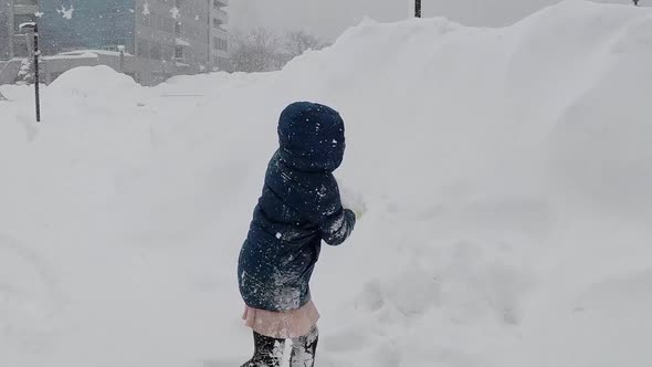 Asian Child Playing Under Snow Fall