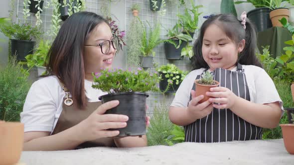 Asian cute child girl helps her mother to care for plants