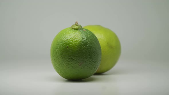 Two Lime Fruit Rotating On the Turntable With Pure White Background - Close Up Shot