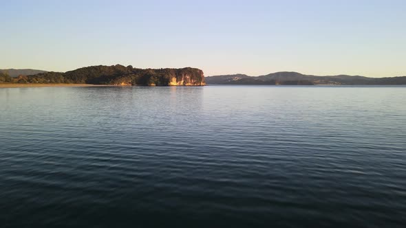 Flying across Cooks bay in Coromandel at sunrise