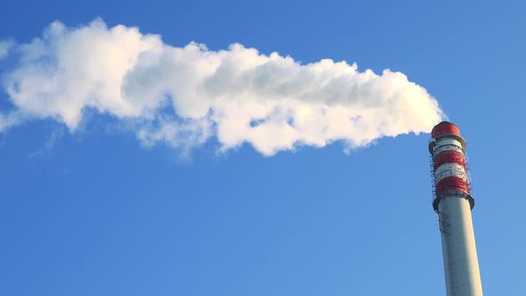 A Smokestack Emits Smoke - the Clear Blue Sky in the Background