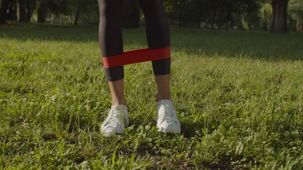 Female Legs Exercising with Resistance Band in Park