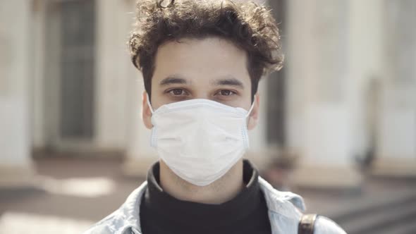 Headshot of Young Caucasian Brunette Man with Brown Eyes in Covid19 Face Mask Looking at Camera