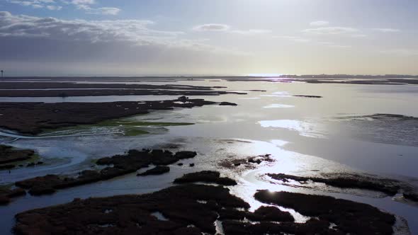 An aerial shot over Baldwin Bay near Freeport, NY during sunset. The camera tilt up & dolly in over