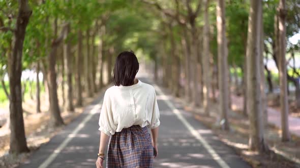 Woman walking along bicycle lane in park