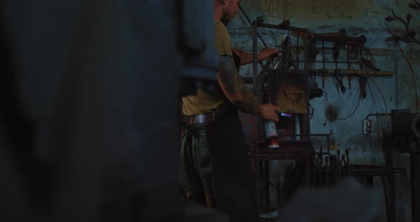 Man is Kindling Blacksmith Furnace in Smith Young Modern Craftsman in Workshop  Prores