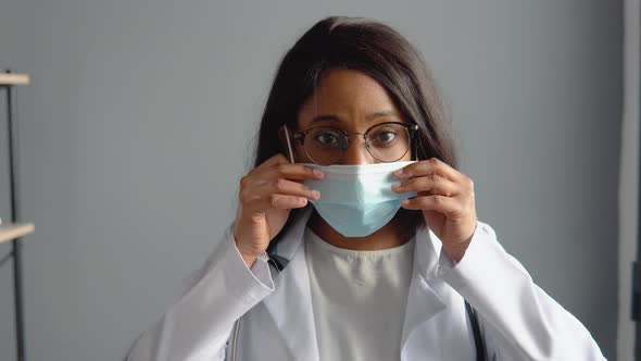 Young Indian Female Doctor Puts on a Protective Blue Mask