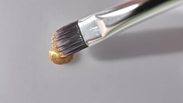 Gold Gel Fluid with Flowing Down on a White Surface