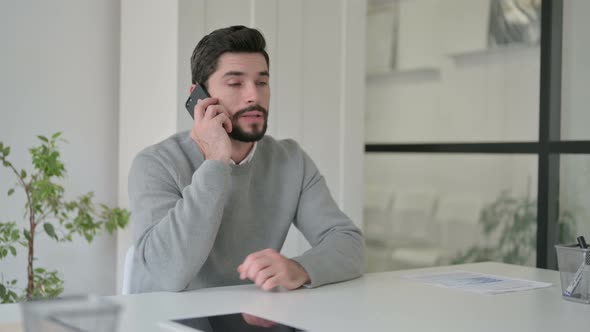 Young Man Talking on Smartphone in Office