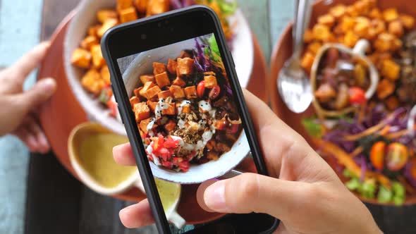 Closeup Of Hands Taking Picture Of Vegan Food Using Cell Phone