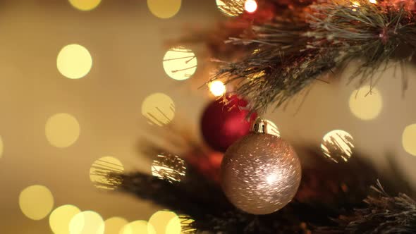 Happy New Year Christmas Tree Decorate with Gold Ball Swinging on Branch on Background Bokeh of