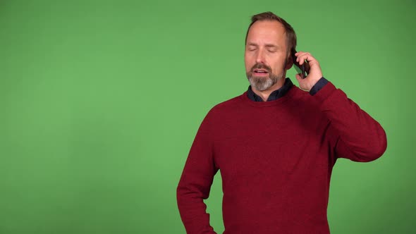 A Middleaged Handsome Caucasian Man Argues on a Smartphone  Green Screen Background
