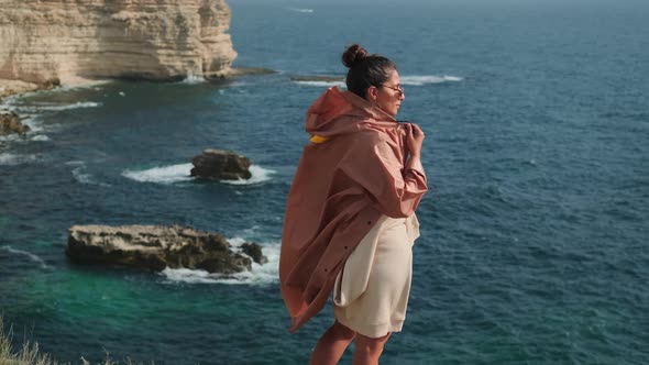 Beautiful Young Woman is Admiring Seascape From Cliff