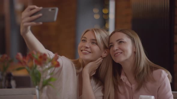 Happy Mother and her Adult Daughter Taking Selfie in Cafe