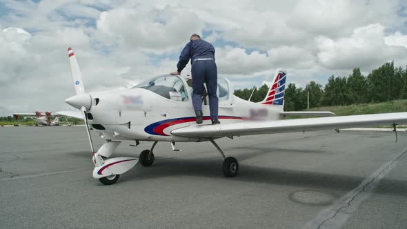 Mature Pilot Getting into Plane