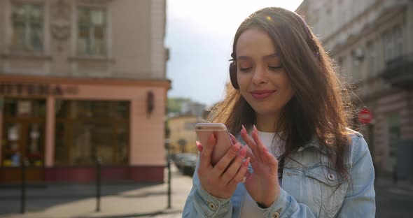 The girl is texting and listening to music