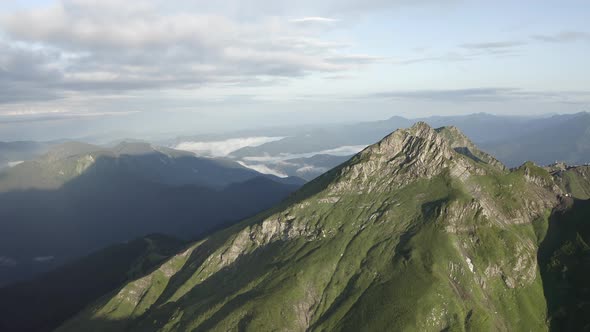 Natural Mountain Peak Cliff Terrain at Morning Surrounded Cloudy Blue Sky Organic Landscape