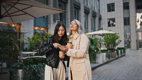 Asian Mature Mother and Adult Daughter Searching for Information About Buildings Around Them in