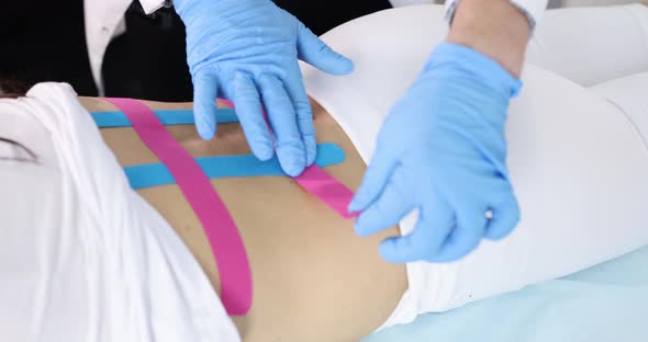 Doctor Glues Kinesio Tape to Patient Spine Slow Motion  Movie