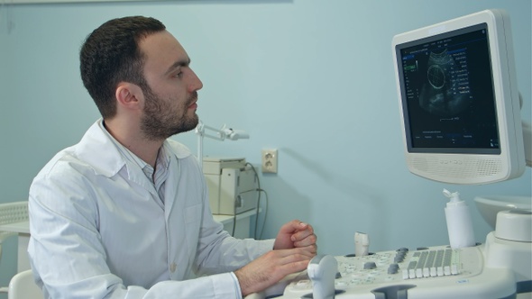 Young doctor with ultrasound diagnostic machine