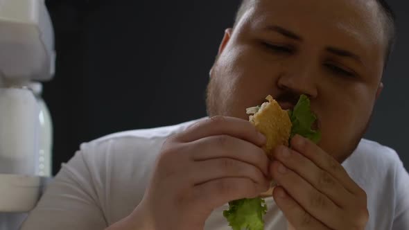 Fat Man Eagerly Eating Burger at Night, Psychological Food Dependence, Addiction