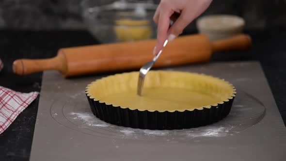 Woman Making French Tart in the Kitchen, Prick the Dough with a Fork