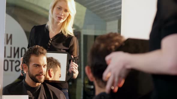 Female hairdresser showing man his haircut in mirror